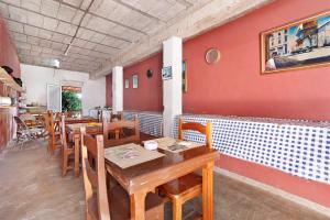 a restaurant with wooden tables and chairs and a red wall at Vivienda V Torres 4 in Vega de San Mateo