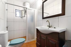 a bathroom with a sink and a toilet and a mirror at Vivienda V Torres 4 in Vega de San Mateo