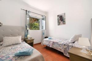 a bedroom with two beds and a window at Vivienda V Torres 4 in Vega de San Mateo