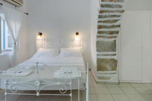a white bedroom with a white bed in a room at Politimis Studio N7 in Amorgos