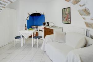 a living room with a white couch and a table at Politimis Studio N7 in Amorgos