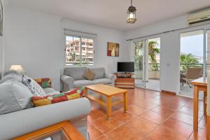 a living room with a couch and a table at Beachfront apartment Torrox Costa in Torrox