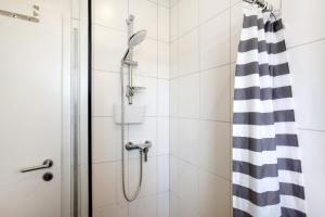 a shower with a black and white shower curtain at Ferienwohnung Keil in Balve