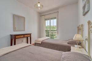 two beds in a room with a window at Beachfront apartment Torrox Costa in Torrox +27 photos