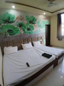 a bedroom with a large bed with a painting on the wall at Agam Homestay - Few Steps From golden temple in Amritsar