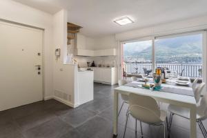 a kitchen and dining room with a table and chairs at New Eleven Apartment on Como Lake in Oliveto Lario