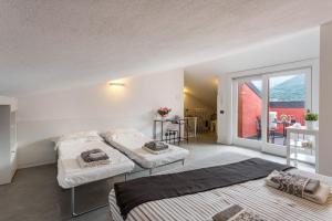 two beds in a room with a balcony at New Eleven Apartment on Como Lake in Oliveto Lario