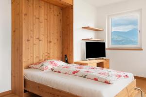 a bedroom with a bed and a flat screen tv at Haus Pferscher in Barbiano