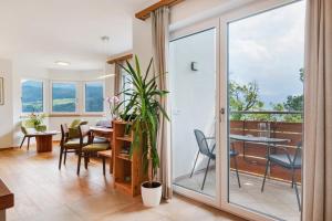 a living room with a table and chairs and a balcony at Haus Pferscher in Barbiano
