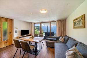 a living room with a couch and a table at Sunnseitn Lodge Apartment Alps in Moso +6 photos