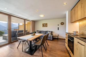 a kitchen and living room with a table and chairs at Sunnseitn Lodge Apartment Alps in Moso