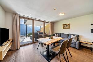a living room with a table and a couch at Sunnseitn Lodge Apartment Alps in Moso
