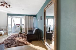 a mirror in a living room with a chair and a couch at Domus Lux 404 in Bad Säckingen