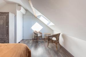 a bedroom with a bed and two chairs and a table at Chalet 2 Pièces Avec Terrasse in Ouzous