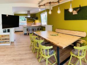 a dining room with a wooden table and yellow chairs at Ferienhaus Urwald in Hofgeismar +18 photos