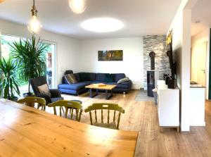 a living room with a blue couch and chairs at Ferienhaus Urwald in Hofgeismar