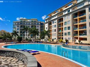 a swimming pool in front of some apartment buildings at Apartamento Isla Feliz in San Miguel de Abona