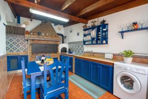 a kitchen with blue cabinets and a washer and dryer at Casa Matyas in Icod de los Vinos