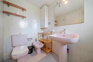a bathroom with a white toilet and a sink at Cambrils park in Cambrils