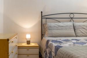 a bedroom with a bed and a lamp on a night stand at Casa Carmela 53 in Ragusa