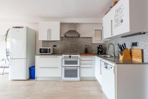 a kitchen with white appliances and white cabinets at Ca La Nyca in Tossa de Mar