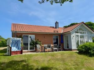 a small house with a patio and a table and chairs at Weidenuferhaus in Kosel