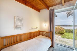 a bedroom with a bed and a sliding glass door at Weidenuferhaus in Kosel