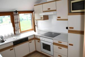 a kitchen with white cabinets and a sink and a window at Ferienwohnung Bergerhöh in Todtnauberg