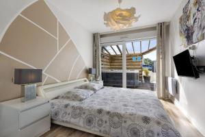 a bedroom with a large bed and a television at Maison d'Elise in Kerlouan +21 photos