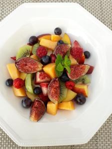 a white plate filled with fruit on a table at Chambres d'hôtes Chez Mathilde in Eaux-Puiseaux