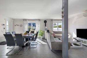 a dining room and living room with a table and chairs at Maison d'Elise in Kerlouan