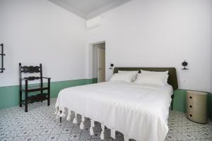 a bedroom with a large white bed with green walls at Villa Capobianco in Polignano a Mare