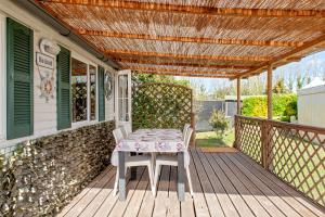 a table and chairs on a deck with a pergola at Oasis on the river 2 in Marina di Pisa
