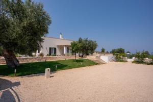 a white house with a tree and a driveway at Villa Capobianco in Polignano a Mare
