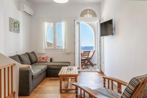 a living room with a couch and a view of the ocean at Ammos Tinos in Istérnia