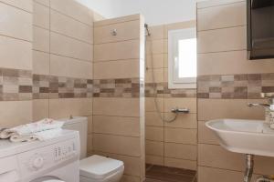 a bathroom with a toilet and a sink at Ammos Tinos in Istérnia +12 photos