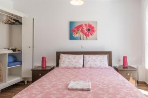 a bedroom with a pink bed with two night stands at Ammos Tinos in Istérnia