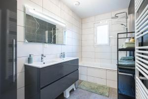 a bathroom with a sink and a mirror and a tub at Maison vélo et ski in Saint-Jean-de-Maurienne +19 photos