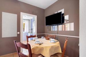 a dining room with a table and a tv at Duplex Luminoso Campo de Golf in Islantilla