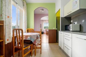 a kitchen with a table and a microwave at Caseta de l'avi in Camarles