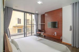 a bedroom with a large bed and a large window at MAY HOMESTAY Villa in Hue