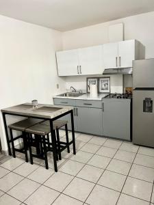 a kitchen with a table and a stove and a refrigerator at Departamento privado in Tijuana