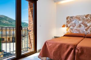 a bedroom with a bed and a large window at Quercus in Navaluenga
