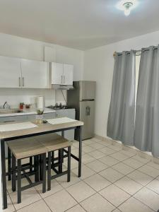 a kitchen with white cabinets and a table in it at Departamento privado in Tijuana +3 photos