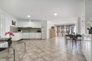 a kitchen with white cabinets and a table and chairs at Apartamento Las Flores5 in San Bartolomé