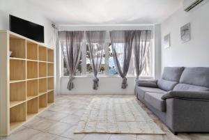 a living room with a couch and two windows at Apartamento Las Flores5 in San Bartolomé