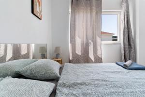 a bedroom with a bed with pillows and a window at Apartamento Las Flores5 in San Bartolomé +9 photos