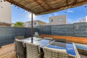 an outdoor patio with a glass table and chairs at Chambre Villa illiade in Jacou