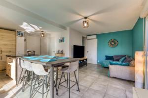 a kitchen and living room with a table and stools at Chambre Villa illiade in Jacou