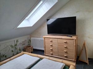 a living room with a flat screen tv on a dresser at Ferienwohnung Anke Günther Dach in Bad Kissingen